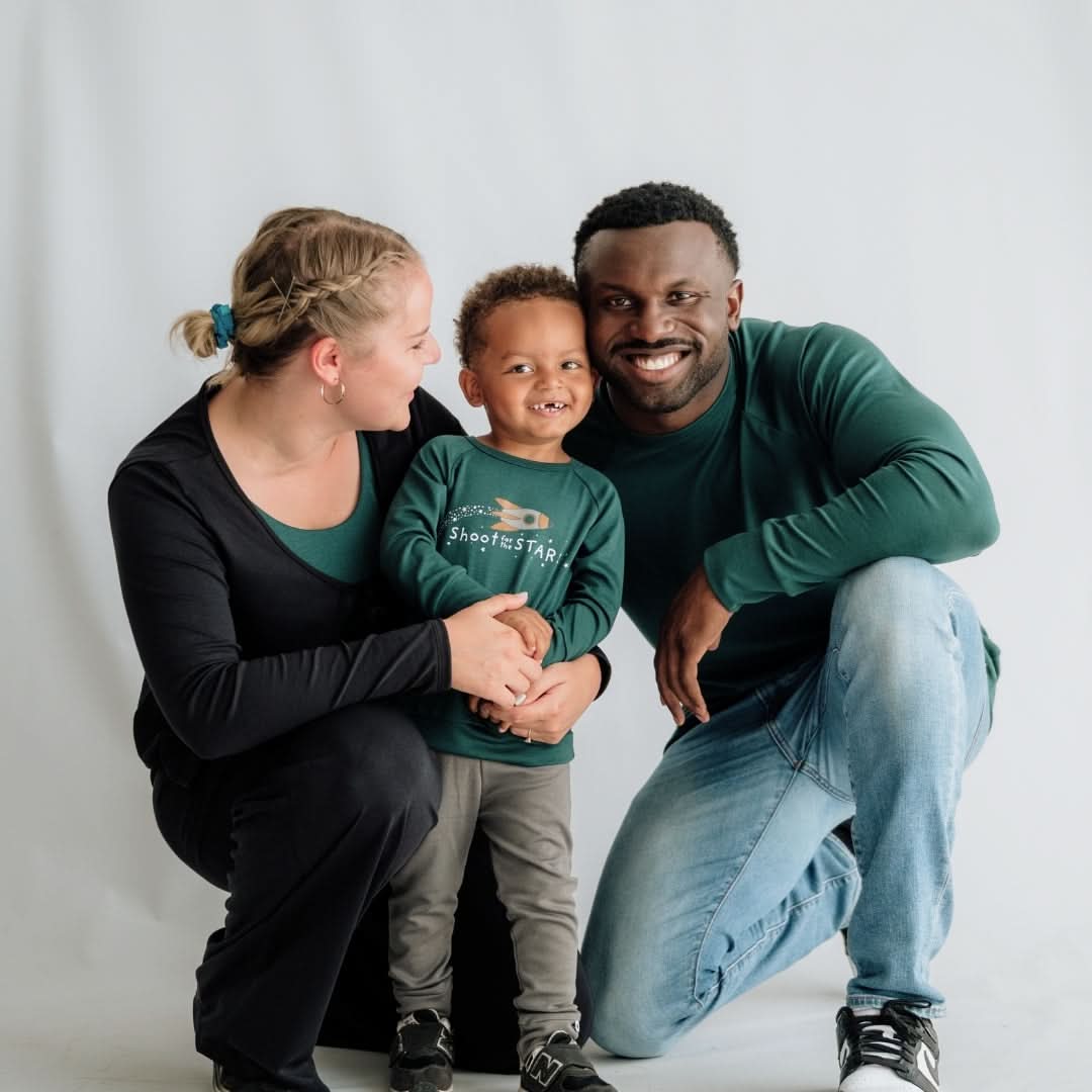 A woman, a young boy, and a man smile together against a plain background, wearing relaxed fit Adult Unisex Bamboo Raglan Pullovers by Little & Lively in green and black tones, offering cozy comfort with Canadian-inspired style.