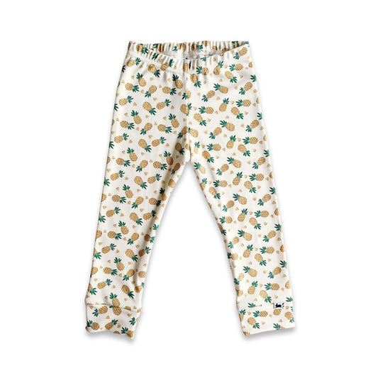 Little & Lively Kids Bamboo Leggings | Prints: White ankle-length youth leggings with an elastic waistband, featuring small yellow pineapples and green leaves. Displayed on a plain white background.