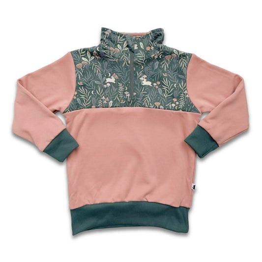 The Little & Lively Kids Bamboo Fleece Half-Zip features pink sleeves and body, green cuffs, waistband, chest panel and collar with a woodland animal and plant design. Ethically made in Canada.