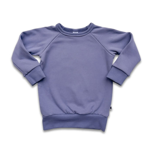 The Little & Lively Baby/Kids Bamboo Fleece Raglan Pullover in solid light purple features ribbed cuffs, collar, and waistband for comfort. Ethically made, it's shown laid flat on a white background.